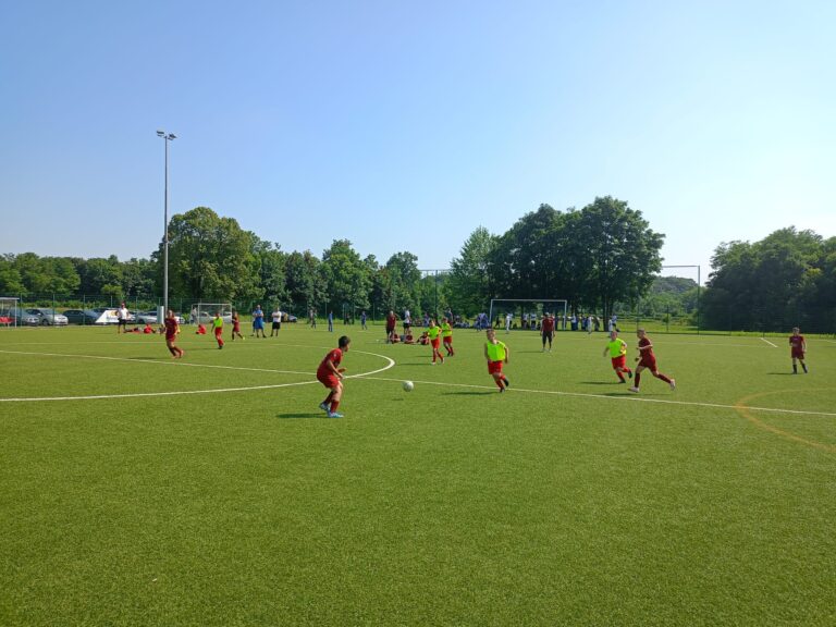 Ragazzi che giovano a calcio, maglie blue e rosse