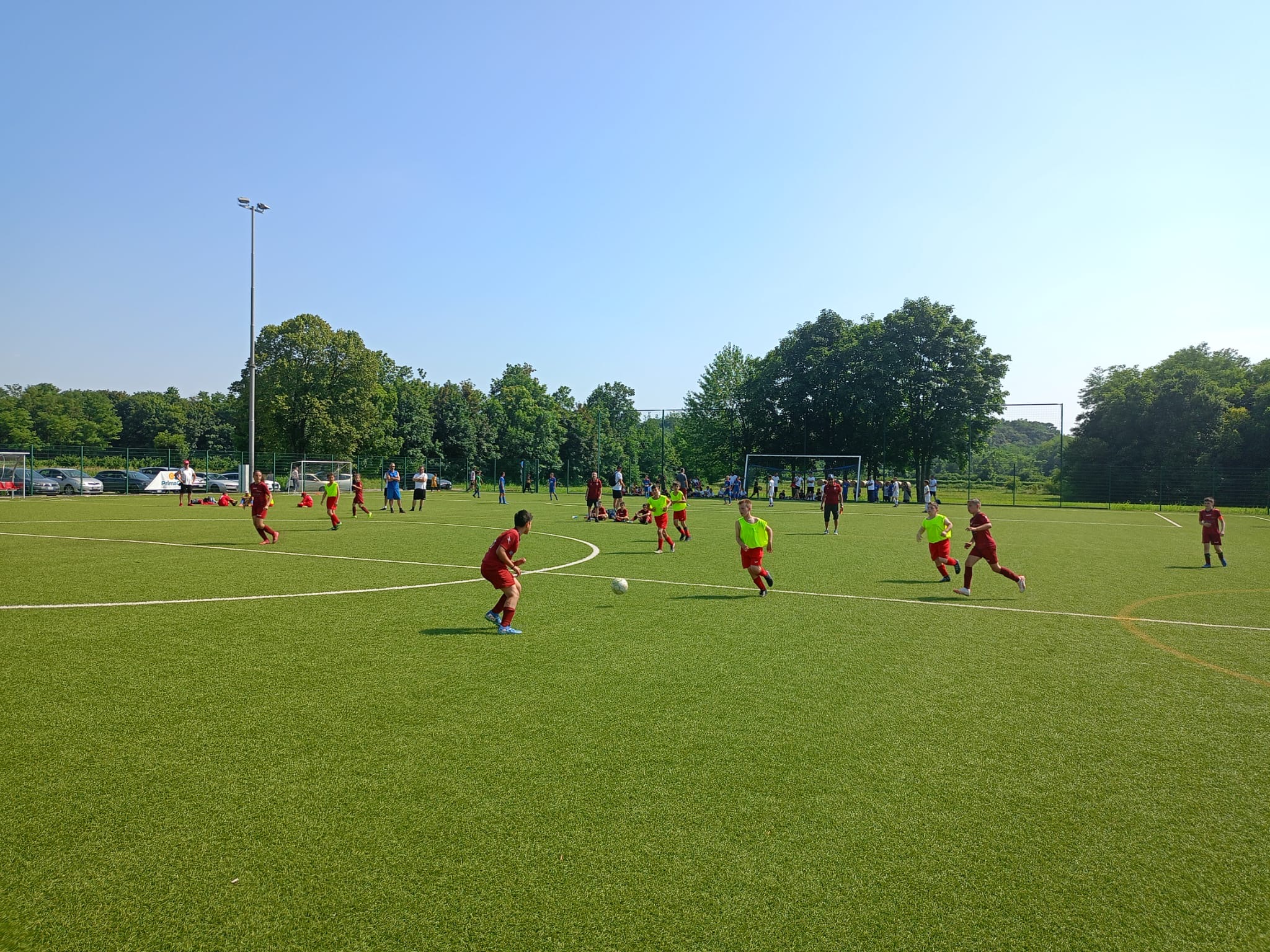 Ragazzi che giovano a calcio, maglie blue e rosse